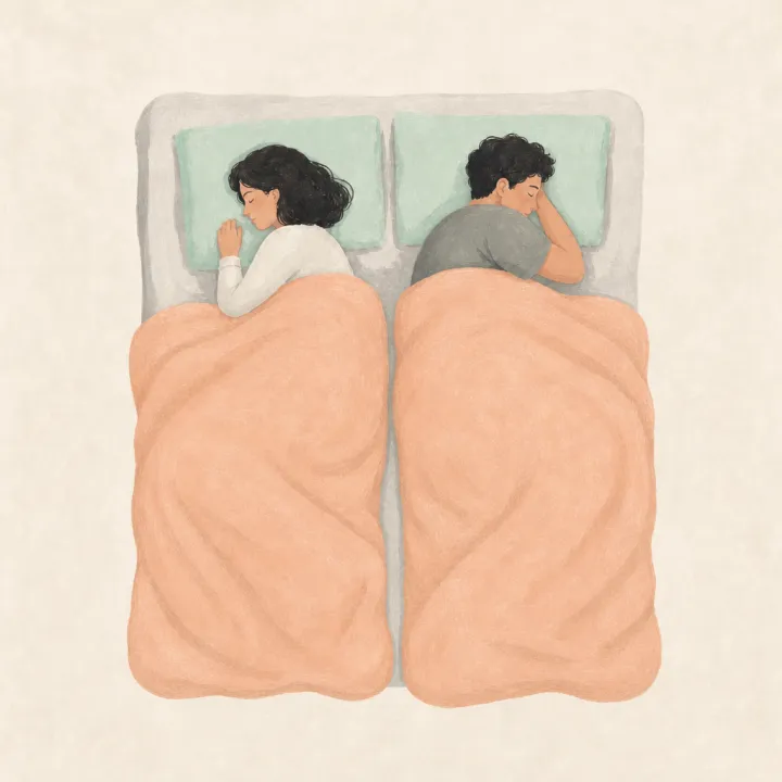 A couple in bed under two separate blankets