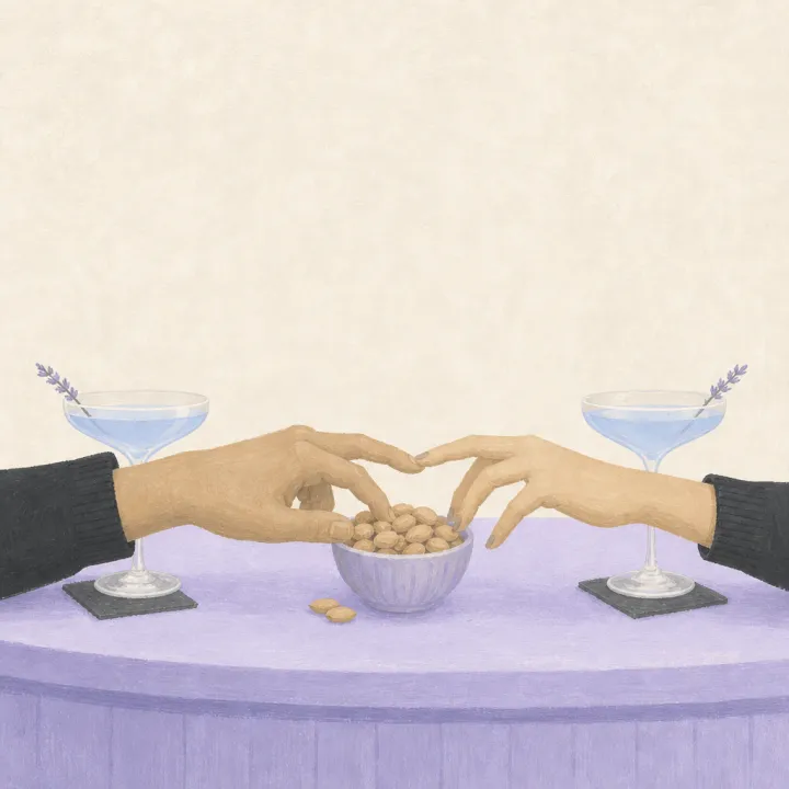 Two hands reaching for the same bowl of peanuts at a bar